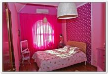 Ремонт дома в детской комнате с арочным окном и двумя видами обоев в розовых тонах
