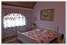 Ремонт дома в спальне с косыми деревянными потолками и арочным окном