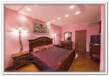 Ремонт квартир в спальне в розовом цвете с выступающим потолком и точечными светильниками