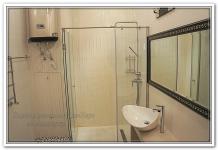 Ремонт квартир в ванной с белой плиткой, стеклянной душевой и водонагревателем